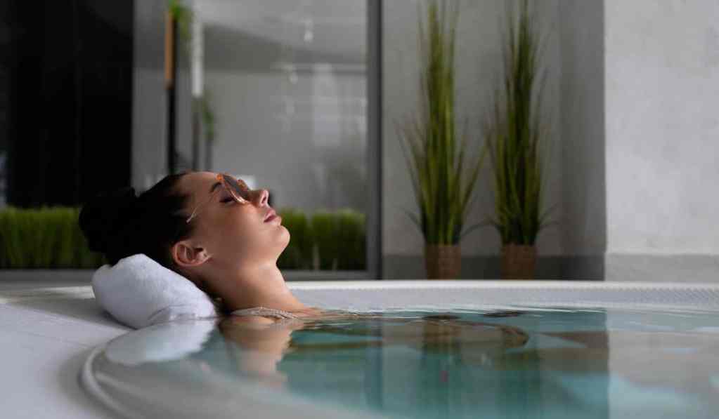 Mujer en jacuzzi, disfrutando de tranquilidad y bienestar.