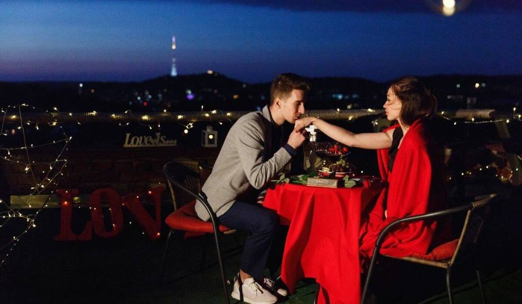 A couple sits at a table, enjoying the view