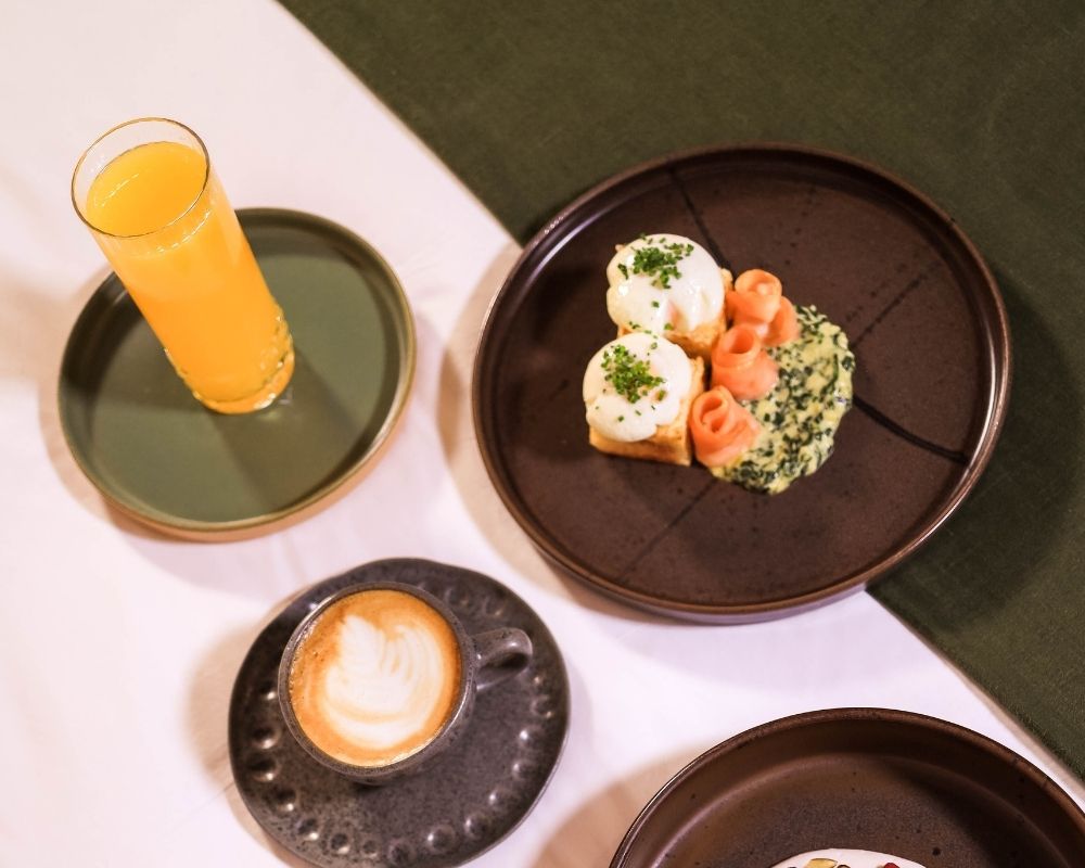 A table set with various plates of food and drinks, inviting and ready for a meal gathering.
