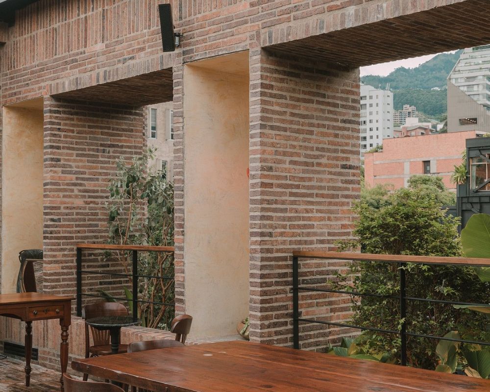 hotel zarzo con mesas y sillas en una terraza al aire libre.