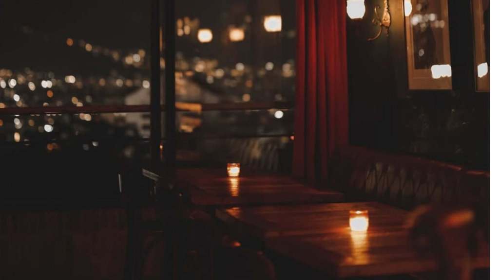 Candlelit bar with panoramic views of the city illuminated