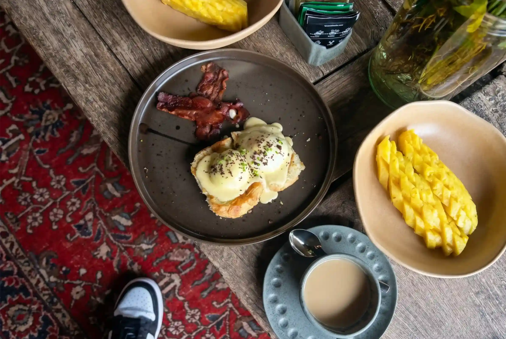 Huevos benedictinos con tocineta y piña en brunch de Provenza, Medellín, cerca de Hotel El Zarzo.