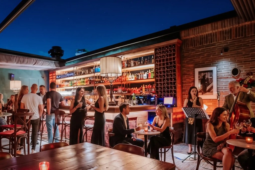 Bar con música jazz en vivo y personas reunidas en Provenza Medellín de noche.