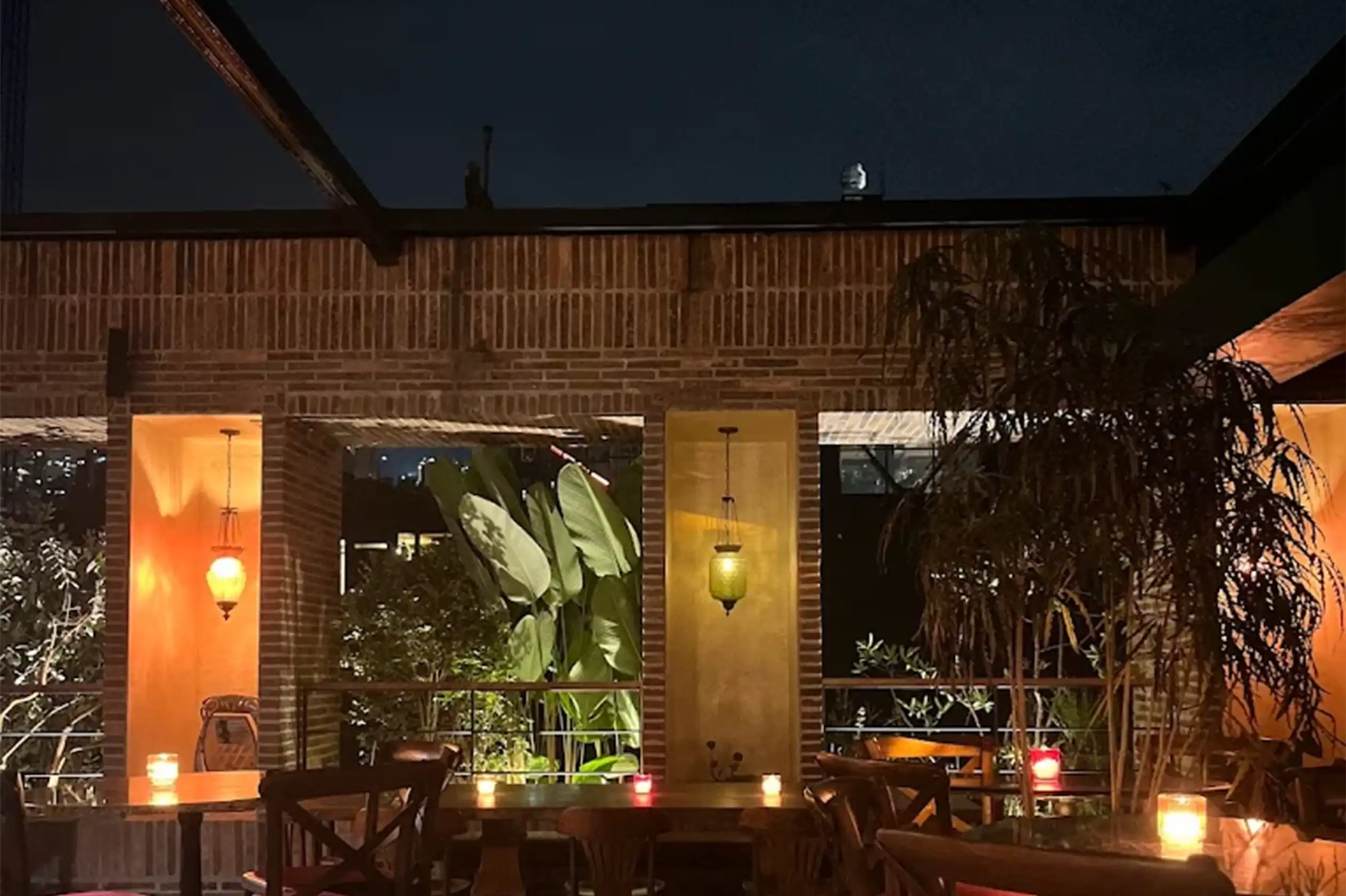 El Zarzo Bar con mesas, velas y vegetación tropical en El Poblado Medellín.